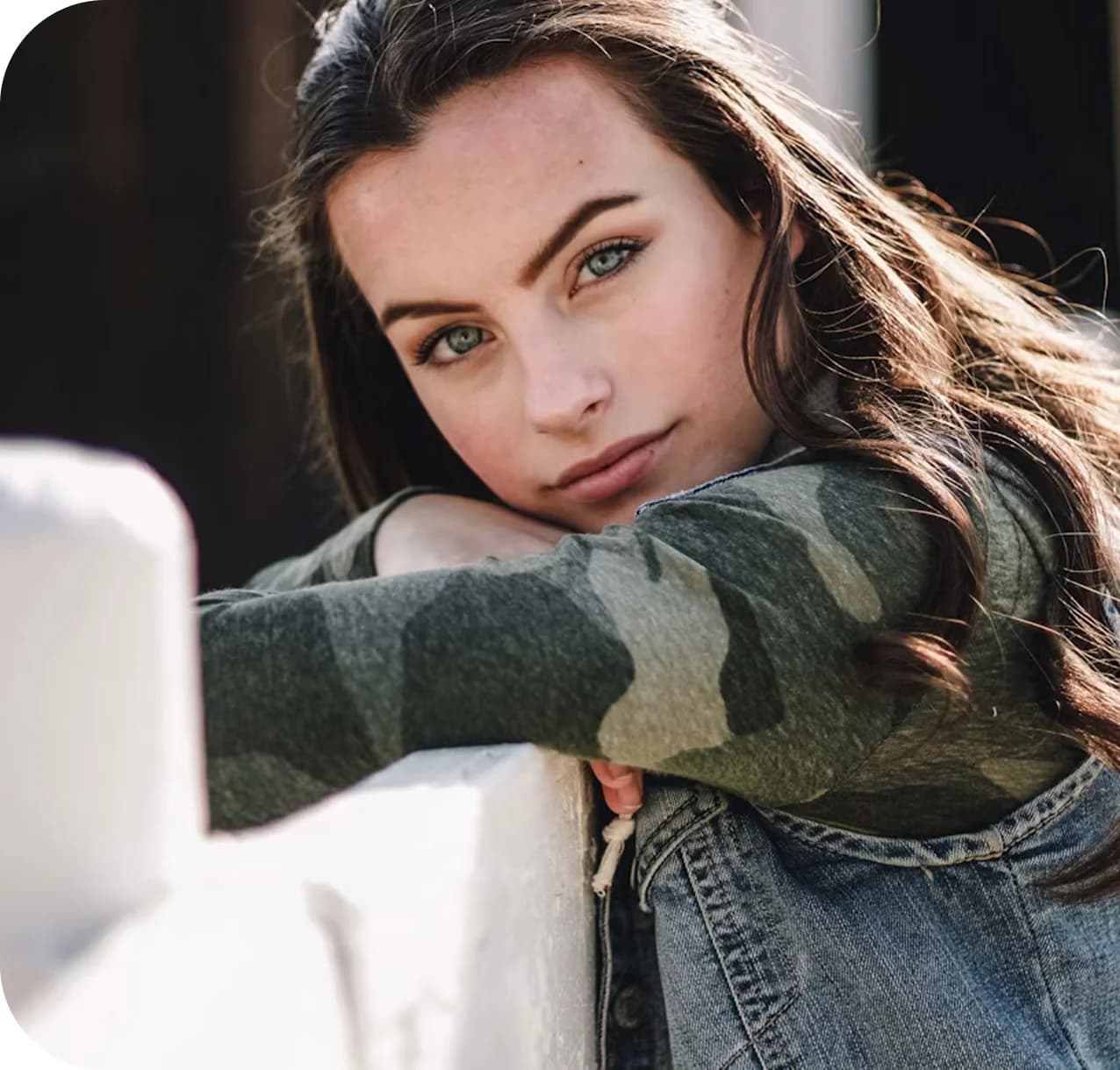 Woman smiling while leaning on fence